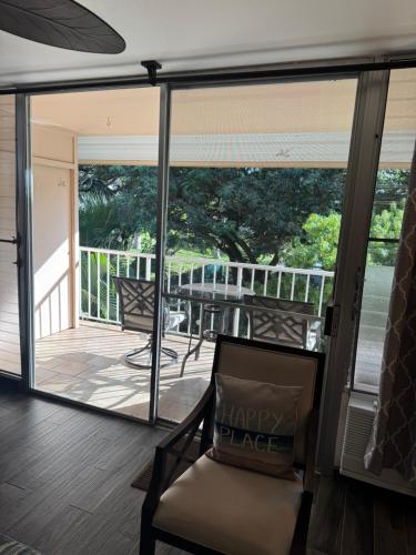 a screened in porch with a chair and a balcony at The Happy Hideaway - Maui Calm by the Ocean in Kihei