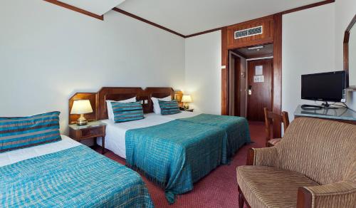 a hotel room with two beds and a couch at Hotel Lux Mundi in Fátima