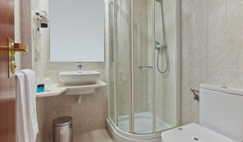 a bathroom with a shower and a sink and a toilet at Hotel Lux Mundi in Fátima