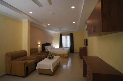 a large living room with a couch and a bed at Veliyil Towers in Alleppey