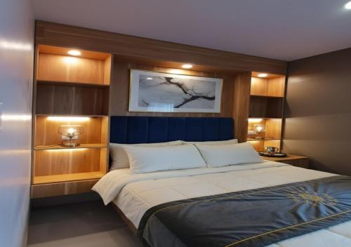 a bedroom with a large bed with a blue headboard at Ubec Vacation Home - Royal Oceancrest Mactan Cebu Condominium in Cebu City