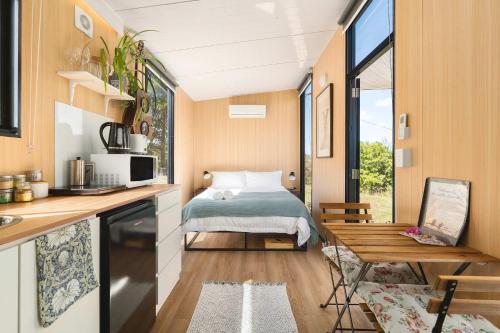 a tiny house with a bed and a table at Kanimbla Sunsets by Tiny Away in Kanimbla