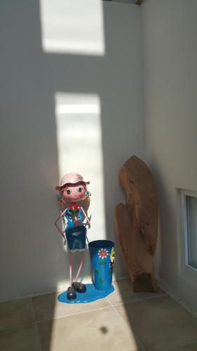 a toy girl is standing next to a trash can at 7 Milefog B&B in Yuli
