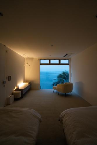 a bedroom with a window and a bed and a couch at Amatera in Kami Amakusa