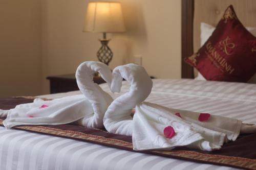 two towels shaped like swans are on a bed at Khanh Linh Hotel in Pleiku