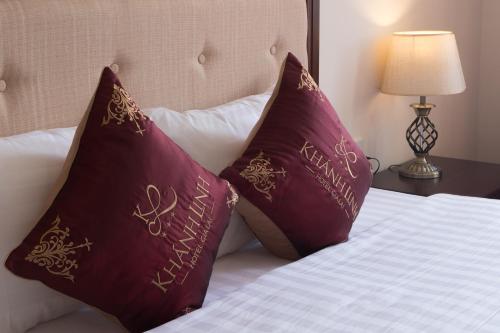 two burgundy pillows sitting on top of a bed at Khanh Linh Hotel in Pleiku