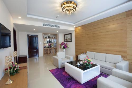 a living room with white furniture and a purple rug at Khanh Linh Hotel in Pleiku