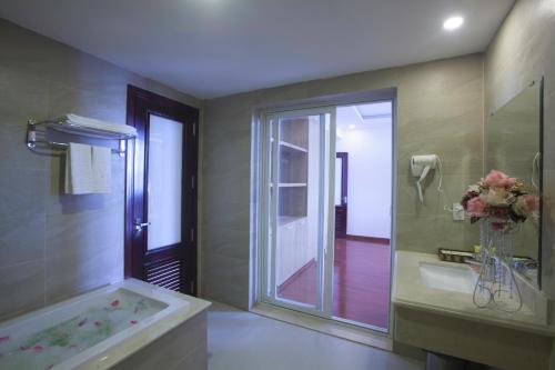 ein Bad mit einer Badewanne und einer ebenerdigen Dusche in der Unterkunft Khanh Linh Hotel in Pleiku