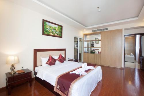 a bedroom with a large white bed and a bathroom at Khanh Linh Hotel in Pleiku