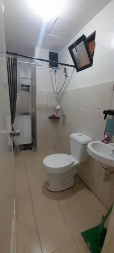 a bathroom with a toilet and a sink at Ubec Vacation Home - Royal Oceancrest Mactan Cebu Condominium in Cebu City