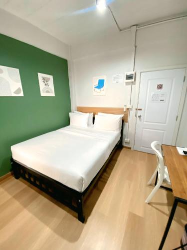 a bed in a room with a green wall at 9TY hotel (ninety hotel) in Bangkok