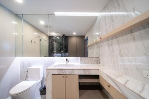 a bathroom with a sink and a toilet and a mirror at Private Residents in Surin Mida in Surin Beach