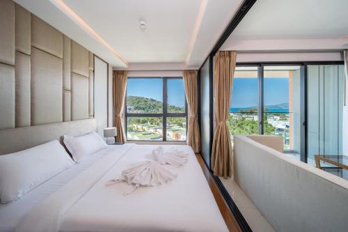 a bedroom with a white bed with a large window at Private Residents in Surin Mida in Surin Beach
