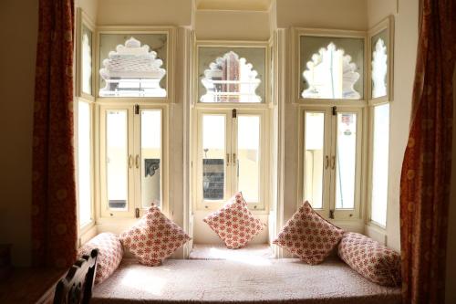 a group of pillows sitting in front of windows at Hotel Pratap Bhawan in Udaipur
