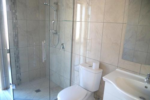 uma casa de banho com um chuveiro, um WC e um lavatório. em A Touch of Class em Greymouth