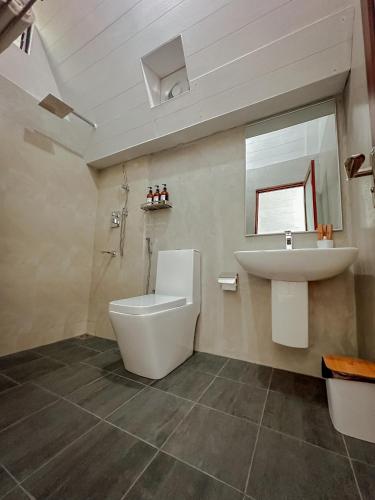 a bathroom with a toilet and a sink at Eco Vibe Resort in Rattota