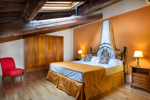 a bedroom with a bed and a red chair at Villa Pitiana in Donnini