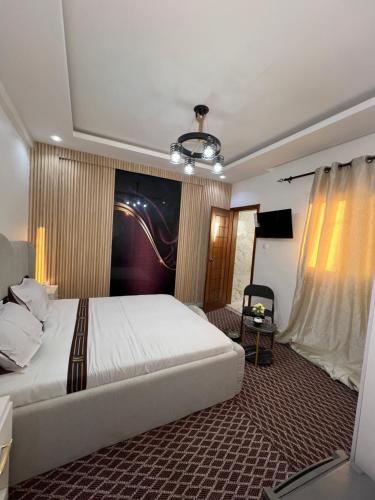 a bedroom with a large white bed and a television at FASARESIDENCE Dakar Point E CHAMBRE NOFLAYE in Dakar