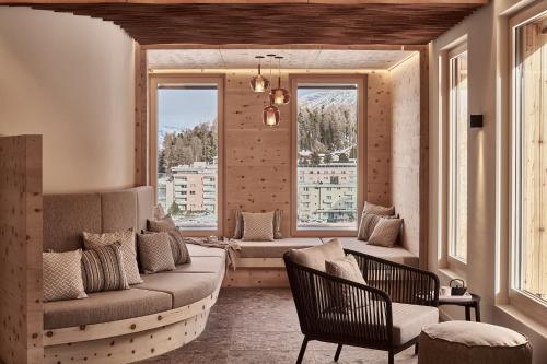 a living room with a couch and two windows at Laudinella Apartments in St. Moritz