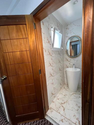 a bathroom with a sink and a mirror at FASARESIDENCE Dakar Point E CHAMBRE NOFLAYE in Dakar