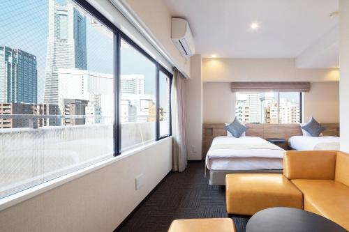 a hotel room with two beds and a large window at Flexstay Inn Sakuragicho in Yokohama