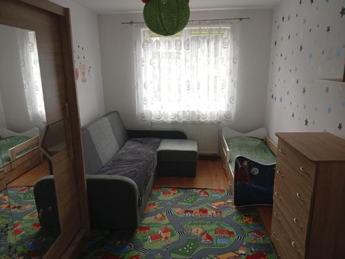 a room with a couch and a bed and a window at Dom na Konwaliowej in Narew