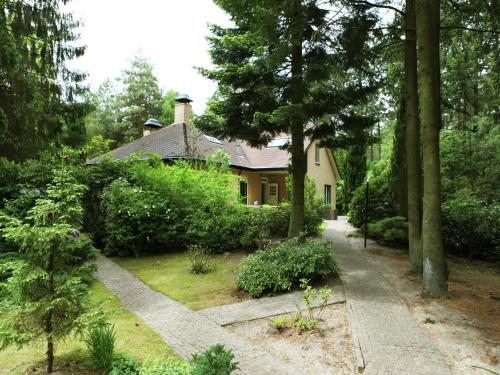 a house in the middle of a garden with a pathway at Quaint Villa in Doornspijk with Swimming Pool in Doornspijk