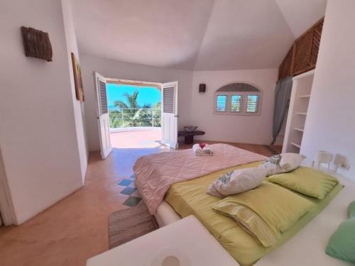 a bedroom with a large bed and an open door at villa vue mer - piscine privée in Las Terrenas
