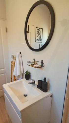 a bathroom with a white sink and a mirror at Seaside at The Dunes in Plettenberg Bay