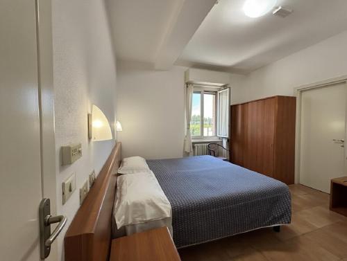 a small bedroom with a bed and a window at Hotel Serena in Riolo Terme