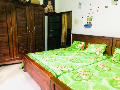 a bedroom with a large bed with green sheets at Shanu home stay in Beliatta