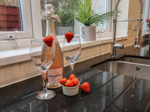a kitchen counter with two wine glasses and strawberries at Bridlington Bay House in Bridlington