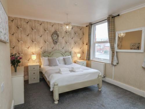 a bedroom with a large white bed and a window at Bridlington Bay House in Bridlington