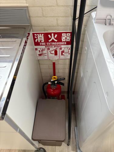 a fire extinguisher in a small room with a sign at シーシャイン北金沢 102号室 in Aomori