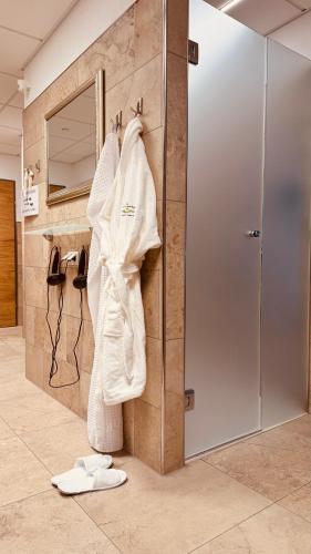 a bathroom with a robe hanging on a wall at Der Marienhof Hotel Garni in Graz