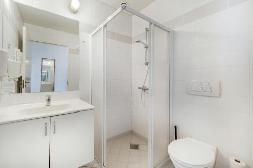 a bathroom with a shower and a toilet and a sink at Hotel Pinenhus in Glyngøre