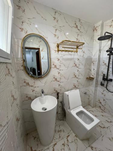 a bathroom with a sink and a toilet and a mirror at FASA RESIDENCE Dakar CHAMBRE TERANGA in Dakar