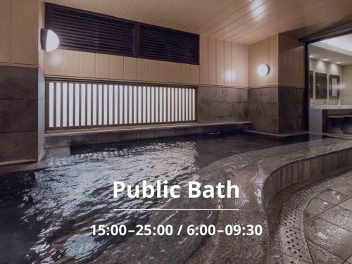 a pool of water in a building with the words public bath at Nishitetsu Inn Kurosaki in Kitakyushu