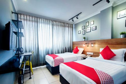 a hotel room with two beds and a desk at OYO 761 City Hotel in Kuala Lumpur
