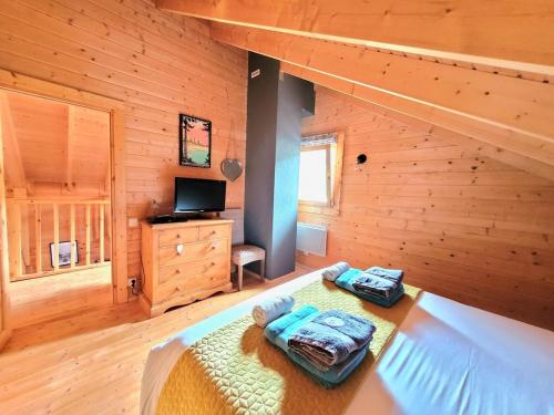 a bedroom with a bed in a log cabin at Chalet Cocoon 6p avec Spa privé in Rochesson