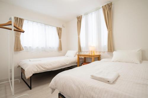 two twin beds in a room with a window at 雪舞-YukiMai in Kutchan