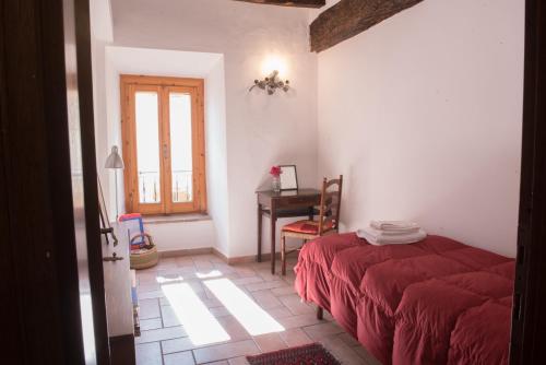 a bedroom with a red bed and a desk at SCAPPO IN UMBRIA, nel vicolo in Amelia