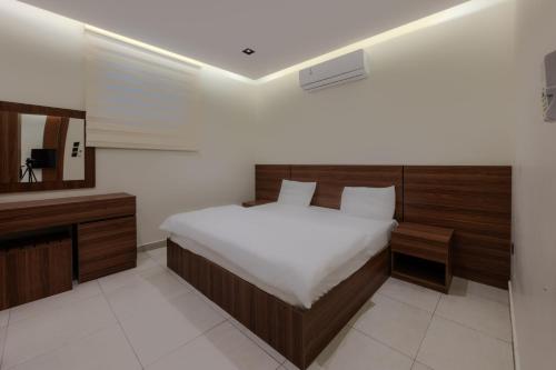 a bedroom with a bed and a mirror and a television at المحروسة للشقق المفروشة Mahrousa Apartment in Medina