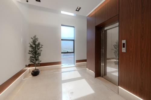 a hallway with a potted tree in the middle of a room at المحروسة للشقق المفروشة Mahrousa Apartment in Medina