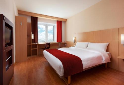 
a hotel room with a bed and a television at Ibis Nizhniy Novgorod in Nizhny Novgorod
