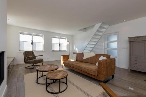 a living room with a couch and two chairs at Welcome in - Familiehuis met ruim terras en speelweide I Oostkapelseweg 32, Serooskerke 'Ooievaar' in Serooskerke