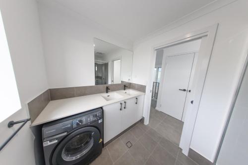 a laundry room with a washing machine and a sink at Private Mezzanine Bedroom, Soaring Ceilings, Sleeps 3, Walk to Cafes, 15 min to Bunbury in Australind