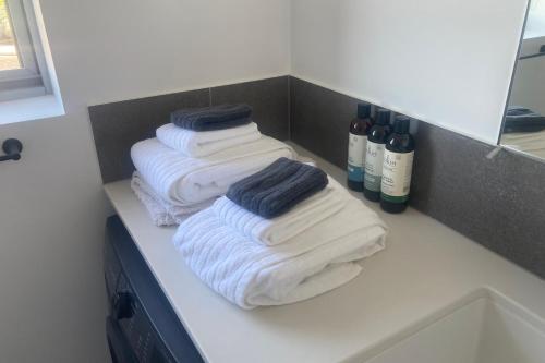 three folded towels sitting on a counter in a bathroom at Private Mezzanine Bedroom, Soaring Ceilings, Sleeps 3, Walk to Cafes, 15 min to Bunbury in Australind