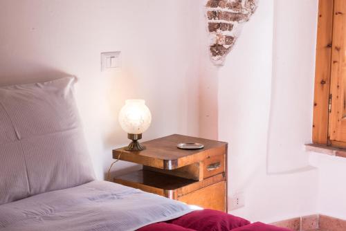 a bedroom with a bed and a table with a lamp at SCAPPO IN UMBRIA, nel vicolo in Amelia