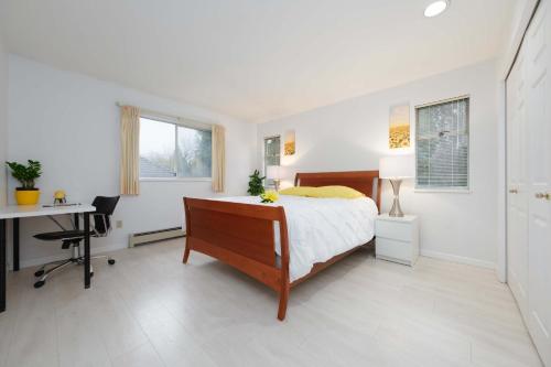 a white bedroom with a bed and a desk and a desk at Private Room with Full Amenities in Cozy House in Vancouver